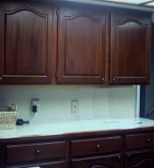 Kitchen cabinets and cupboards refinished in cherry wood color.