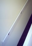 Stair well going to upstairs and showing two-toned wood handrail