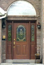 Full view of exterior woodgrained door matching exterior brick of home