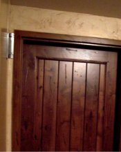 This pictures shows a front view of a real knotty alderwood door with a metal door casing that has been woodgrained to match the door