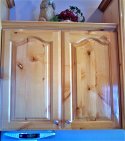 Closeup cabinet view of original finish of knotty alderwood cabinet