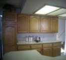Full view of oak finished kitchen cabinets before they were refinished.