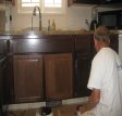 An artist at work applied undercoat to refurbish oak cabinets