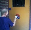 Putting bondo on metal utility door.