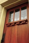 This is an angled view of the marbleized casing and the upper portion of the woodgrained red mahogany door.