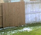 This is a picture of the stained fence next to the fence of a neglected apartment complex fence.
