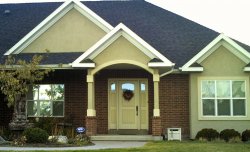 This picture  shows a full view of a home with a painted wood entrance door.