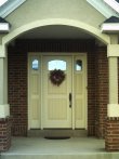 Closeup of painted wood entrance door with archway.