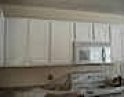 This is a picture of original white wood kitchen cabinets.