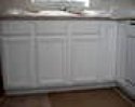 This is a picture of the original white wood sink kitchen cabinets.